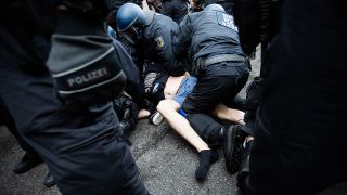 Polizisten nehmen bei einer Kundgebung gegen die Corona-Maßnahmen nahe dem Potsdamer Platz einen Mann fest. (Quelle: dpa/Christoph Soeder)