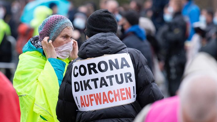 Archivbild: «Corona-Diktatur» und «Aufwachen» steht auf dem Schild eines Teilnehmers einer Demonstration der Initiative «Querdenken». (Quelle: dpa/B. Roessler)