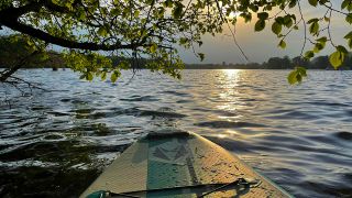 Ein Stand Up Paddle im Sonnenuntergang auf dem Tegler See (Quelle: dpa/Lakomski)