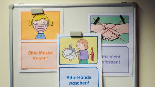 "Bitte Maske tragen" (l-r), "Bitte Hände waschen" und "Bitte nicht anfassen" steht auf einer Magnettafel in einer Grundschule in Berlin. (Quelle: dpa/Annette Riedl)