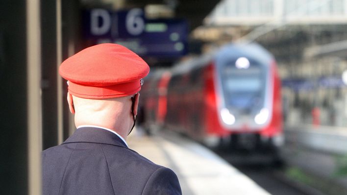 Symbolbild: Zugaufsicht mit roter Dienstmütze der DB Deutsche Bahn. (Quelle: imago images/R. Peters)