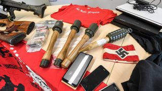 Archivbild: Sichergestellte Waffen, Handgranaten, Telefone und andere Materialien, darunter auch eine Armbinde mit einem Hakenkreuz, liegen bei einem Pressetermin im LKA Brandenburg auf einem Tisch. (Quelle: dpa/J. Kalaene)