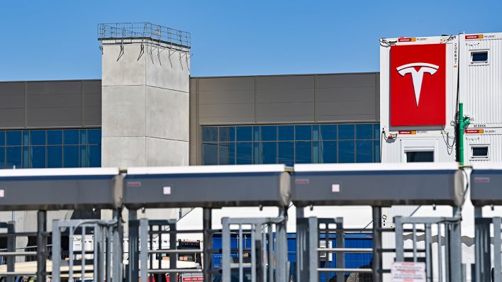 Das Logo von Tesla hängt an einem Container auf der Baustelle der Gigafactory östlich von Berlin. (Quelle: dpa/Patrick Pleul)