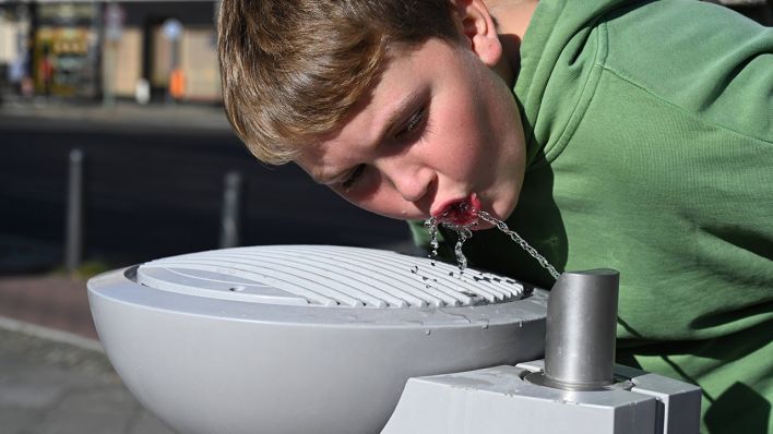 Archivbild: Ein Junge trinkt an einem Trinkbrunnen der Berliner Wasserbetriebe. (Quelle: imago images/P. Schneider)