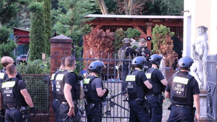 Beamte der Polizei in Berlin leisten dem Bezirksamt Neukölln Amtshilfe beim Bau eines Zaunes um ein Grundstück in Alt Buckow.
