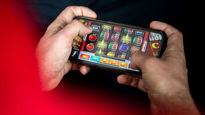 Auf einem Smartphone spielt ein Mann ein Online-Spiel. (Quelle: dpa/Sina Schuldt)