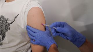 Eine Person kommt ohne Termin ins Impfzentrum Erika-Heß-Eisstadion und lässt sich dort gegen Corona impfen. (Quelle: dpa/Jörg Carstensen)