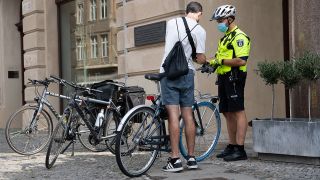 Ein Beamter der Fahrrad-Staffel der Berliner Polizei kontrolliert am 26.07.2021 einen Radfahrer. (Quelle: dpa/Paul Zinken)