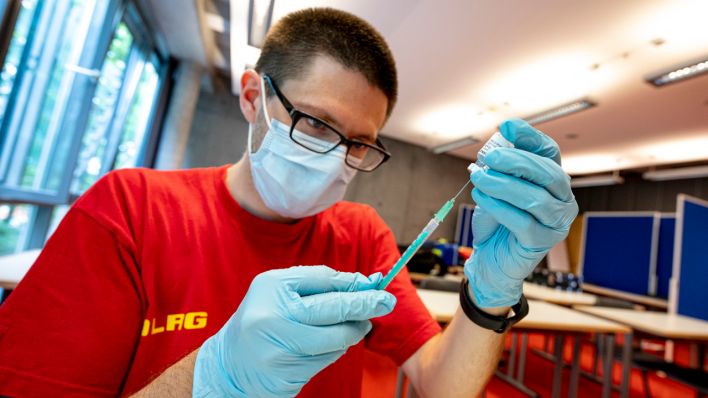 Eine Notfallsanitäter der DLRG zieht an der Universität Potsdam den Corona-Impfstoff von Biontech in eine Spritze (Quelle: DPA/Fabian Sommer)