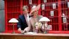 Der niederländische König Willem-Alexander (l) und seine Frau, Königin Maxima, tragen sich in der Kulisse des Films Grand Budapest Hotel in der Medienstadt Babelsberg in ein Gästebuch ein (Bild: dpa/Britta Pedersen)