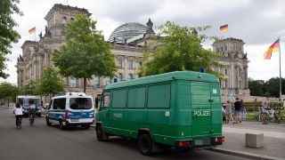 Einsatzwagen der Polizei stehen am Reichstag. Die Polizei will trotz eines Verbots mehrerer Demonstrationen zur Corona-Pandemie am Wochenende mit einem größeren Aufgebot an Einsatzkräften im Stadtgebiet unterwegs sein. (Quelle: dpa/P. Zinken)