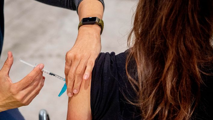 Archivbild: Eine Frau wird in einem Impfzentrum geimpft. (Quelle: dpa/R. Utrecht)