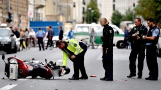 Nach einem schweren Unfall mit einem Motorradfahrer in Berlin-Mitte sichern Polizisten die Unfallstelle. Quelle: dpa