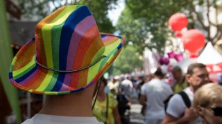 Ein Mann mit einem Hut in den Regenbogenfarben besucht das 27. lesbisch-schwule Stadtfest im Berliner Bezirk Schöneberg. Quelle: dpa/Paul Zinken