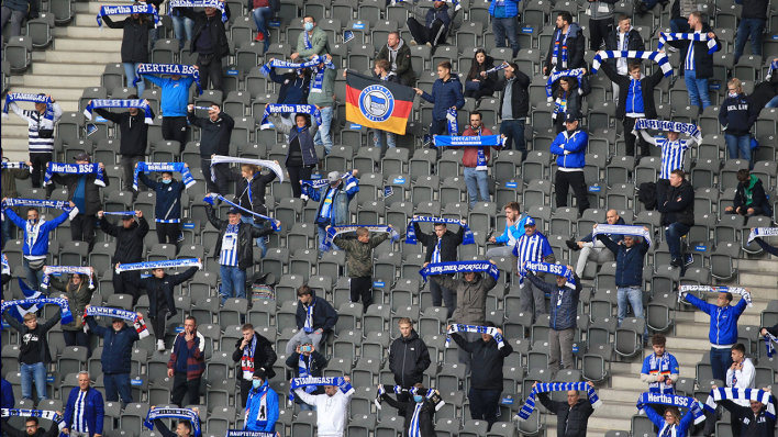 Fans von Hertha BSC halten ihre Schals auf der Tribüne hoch (Quelle: IMAGO/Nordphoto)