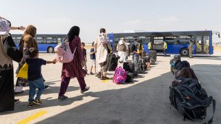 Schutzbedürftige Menschen gehen kurz nach dem Flug aus Kabul zu einem Bus. (Quelle: dpa/Bundeswehr/Marc Tessensohn)