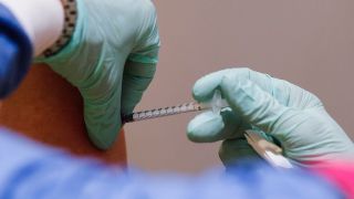 Eine Frau, die in einem Pflegeheim arbeitet, wird im Impfzentrum Arena Treptow gegen das Coronavirus geimpft. (Quelle: Markus Schreiber)