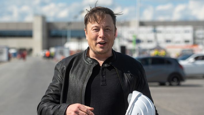 Archivbild: Elon Musk, Tesla-Chef, steht auf der Baustelle der Tesla Fabrik und hält seinen Schutzhelm im Arm. (Quelle: dpa/Christophe Gateau)