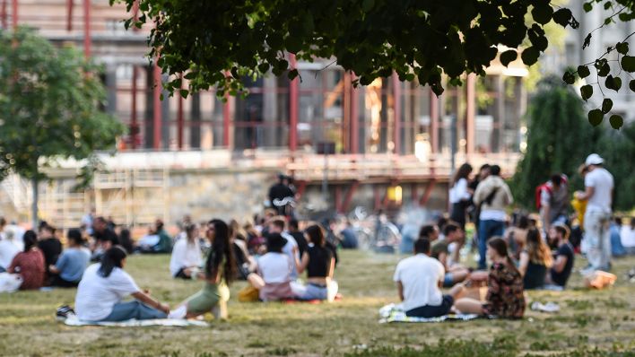 Archivbild: Mehrere Personengruppen sitzen am 14.06.2021 am Abend bei warmen Wetter im James-Simon-Park. (Quelle: dpa/Kira Hofmann)