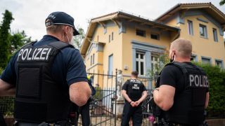 Polizisten stehen am 08.07.2021 in Berlin-Neukölln vor einem Wohnhaus von Mitgliedern eines bekannten arabischstämmigen Clans. (Quelle: dpa)
