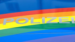 Ausschnitt der Motorhaube mit der Aufschrift: "POLIZEI" unterlegt von einer Regenbogenflagge. (Archiv)