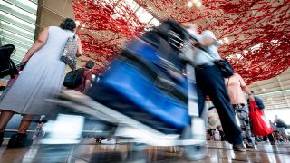 Ein Fluggast läuft mit Kofferwagen durch die Haupthalle des Flughafen Berlin Brandenburg (BER). (Quelle: dpa/Fabian Sommer)
