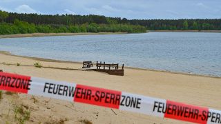 Mit einem Flatterband ist ein Zugang zum Strand des Helenesees abgesperrt (Quelle: DPA/Patrick Pleul)