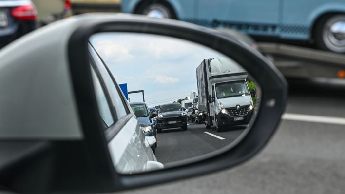 Im Außenspiegel eines Wagen ist zu sehen, wie sich mehrere Fahrzeuge auf der Autobahn stauen (Quelle: DPA/Patrick Pleul)