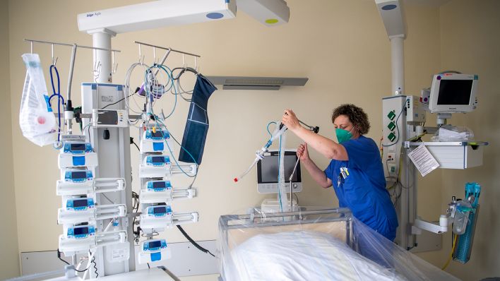 Eine Mitarbeiterin der Intensivstation bereitet ein Intensivbett für einen Coronapatienten vor. (Quelle: dpa/Sina Schuldt)