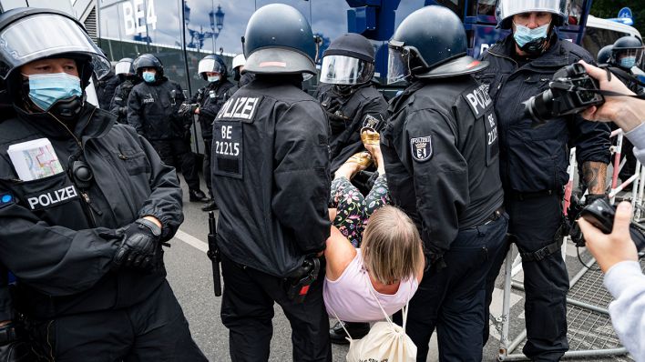 Die Polizei trägt eine Demonstrantin bei einer unangemeldeten Demonstration an der Siegessäule weg. (Quelle: dpa/Fabian Sommer)