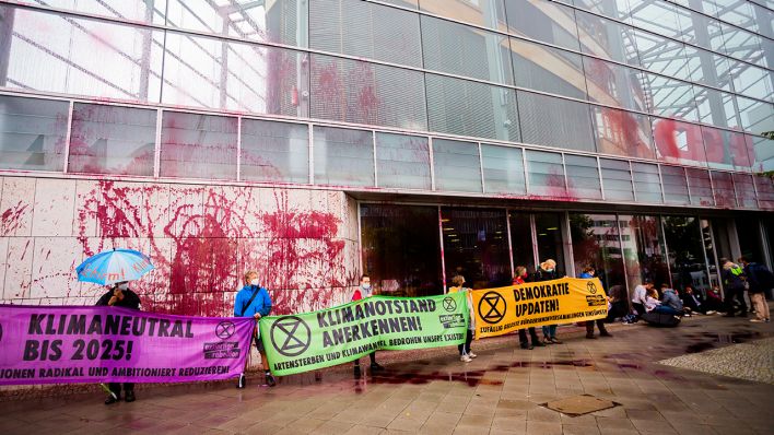 Teilnehmer einer Protestaktion von Umweltaktivisten stehen mit Bannern für eine umweltfreundlichere Klimapolitik vor dem Konrad-Adenauer-Haus, der CDU-Parteizentrale. (Quelle: dpa/Christoph Soeder)