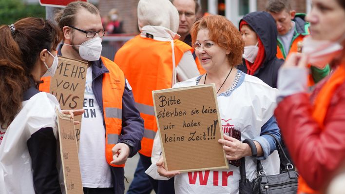 Ein Transparent mit der Aufschrift "Bitte sterben sie leise, wir haben keine zeit" wird bei einer streikbegleitenden Kundgebung vor der Vivantes-Zentrale gezeigt. (Quelle: dpa/Jörg Carstensen)