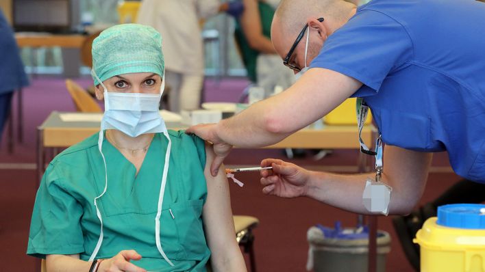 Symbolbild: Eine Krankenhaus-Mitarbeiterin erhält eine Impf-Auffrischung. (Quelle. dpa/B. Wüstneck)