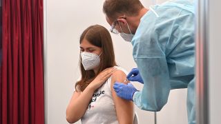 Symbolbild: Eine junge Frau wird von einem Arzt mit einem Corona-Impfstoff geimpft. (Quelle: dpa/S. Simon)
