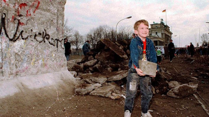 Ein Mauerstück schleppt der kleine Peter am 20. Februar 1990 zur Erinnerung mit. (Quelle: dpa/Peter Kneffel)