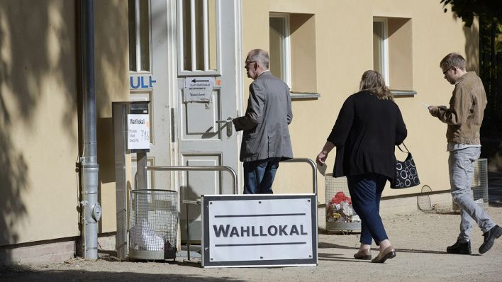 Mehrere Menschen betreten ein Wahllokal im Prenzlauer Berg (Bild: imago images)