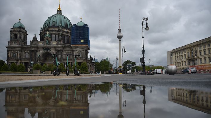 Archivbild: Der Berliner Dom und der Fernsehturm spiegeln sich in einer Pfütze wieder. (Quelle: dpa/S. Braun)