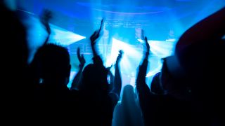 Symbolbild: Die Silhouette von feiernden Menschen in einem Tanzclub. (Quelle: imago images/N. Dahhan)