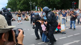 Archivbild: Nach der dritten Aufforderung der Polizei wird eine junge Frau von der Polizei weggetragen. Verbotene Querdenker-Demo auf der Straße des 17. Juni an der Siegessäule. (Quelle: imago images/R. Kremming)
