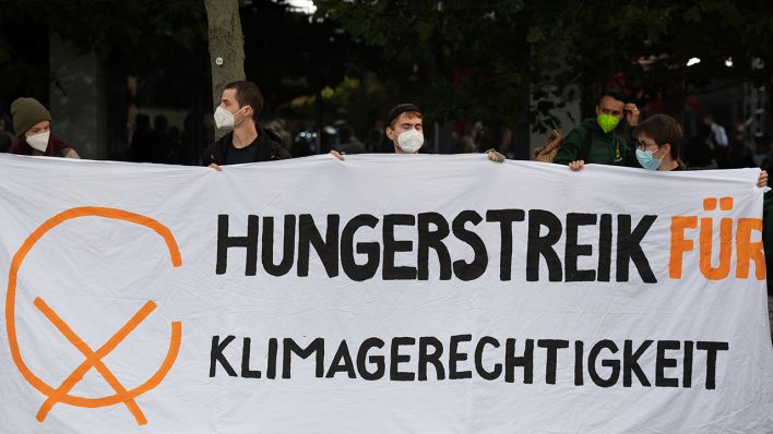 Demonstranten halten vor einem Fernsehstudio in Berlin Adlershof ein Plakat mit der Aufschrift "Hungerstreik für Klimagerechtigkeit".