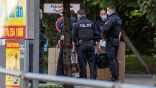 Polizisten stehen auf dem Gelände des Dong Xuan Center mit Kartons. Mit einer Razzia ist die Polizei in Berlin gegen eine vietnamesisch-deutsche Schleuserbande vorgegangen. (Quelle: dpa/Christophe Gateau)