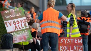 Teilnehmerinnen an einer Demonstration von Beschäftigen der landeseigenen Berliner Krankenhäuser Vivantes und Charité stehen am 14.09.2021 vor dem Hochhaus der Charité. (Quelle: dpa/Paul Zinken)