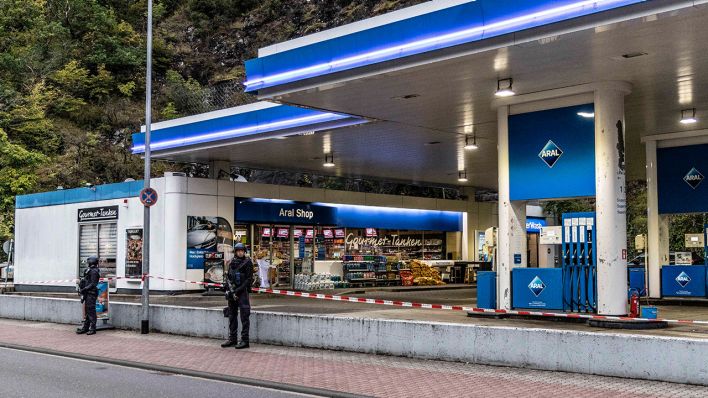 Polizisten sichern am frühen Morgen eine Tankstelle. Ein Angestellter der Tankstelle war in Idar-Oberstein in Rheinland-Pfalz in der Nacht zuvor von einem mit einer Pistole bewaffneten Mann erschossen worden. (Quelle: dpa/Christian Schulz)
