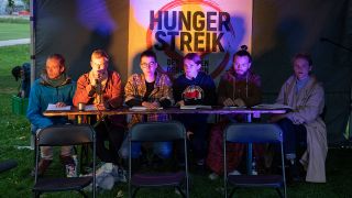 Fünf Klimaaktivisten, begleitet von einer Sprecherin der Gruppe (r), berichten am 23.09.2021 bei einem Pressegespräch über die Erfahrungen ihres beendeten mehrtägigen Hungerstreiks. (Quelle: dpa/Paul Zinken)
