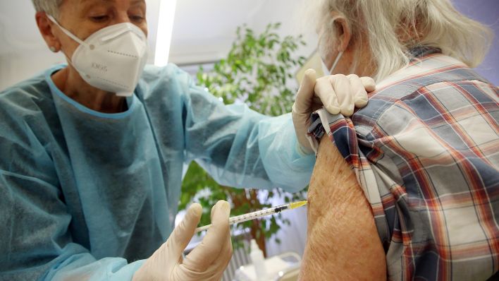 Symbolbild: Ein älterer Mann lässt sich in der Praxis seiner Hausärztin die dritte Impfung mit dem Comirnaty-Impfstoff des Herstellers Biontech/Pfizer injizieren. (Quelle: Wolfgang Kumm/dpa)