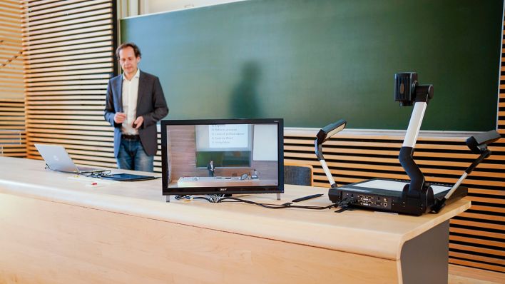 Ein Dozent demonstriert in einem Hörsaal der Universität die Aufzeichnung einer digitalen Vorlesung. (Quelle: dpa/Uwe Anspach)