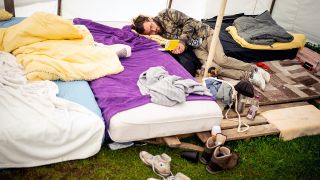 Jakob liegt am Morgen auf einem Matratzenlager in einem Zelt eines Protestcamps im Regierungsviertel. (Quelle: dpa/Kay Nietfeld)