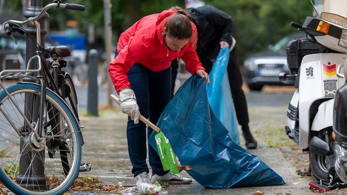 Freiwillige sammeln im Rahmen der Aufräum-Aktion zum World Cleanup Day in der Nähe der Schönhauser Allee Müll von der Straße. (Quelle: dpa/Monika Skolimowska)