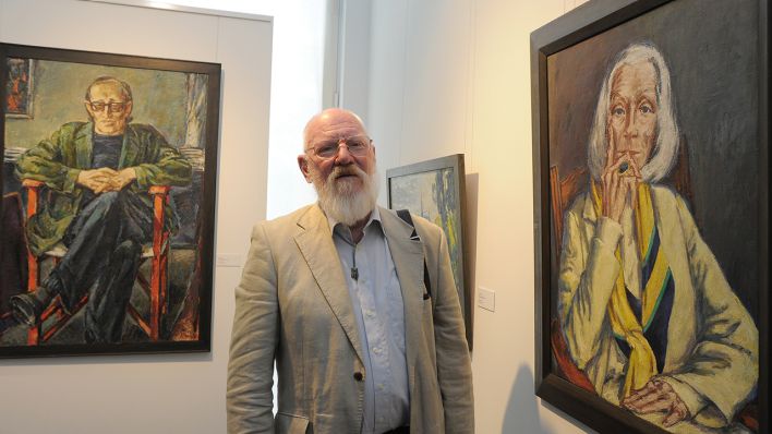 Der Maler Ronald Paris steht in Potsdam zwischen seinen Porträts von Heiner Müller und Inge Keller. (Quelle: dpa/Bernd Settnik)