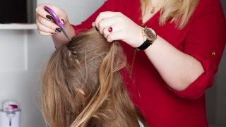 Eine Frau kämmt einem Mädchen die Haare mit einem Läusekamm. (Quelle: dpa/Silvia Marks)